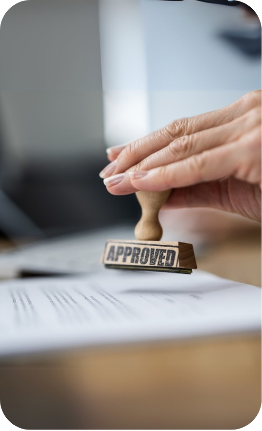 Close-up of a hand stamping an 'Approved' mark on paperwork, representing GHLP Services’ fast and reliable permit approval process in the Greater Houston area.