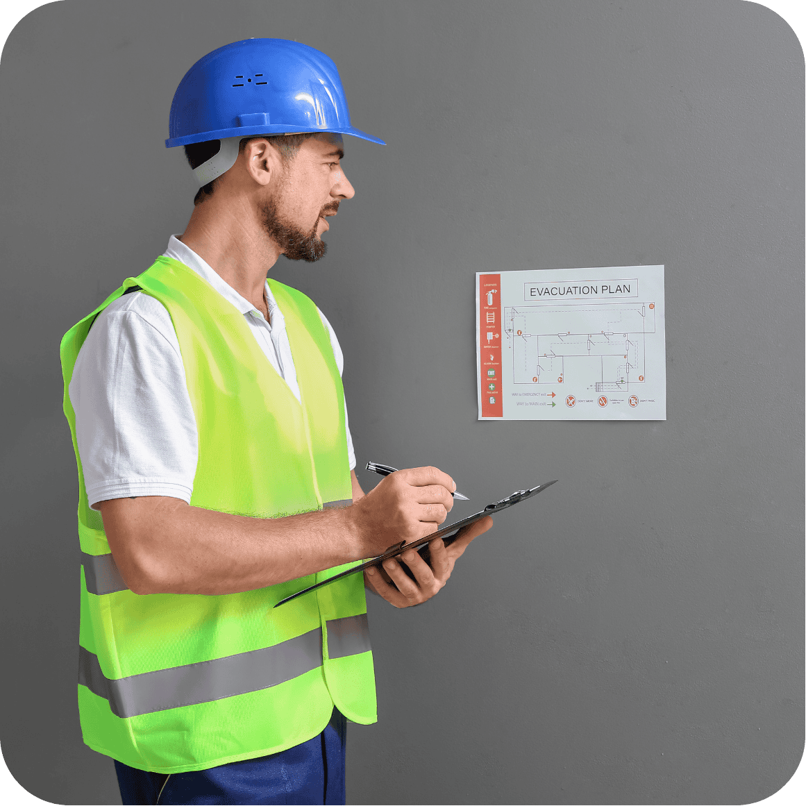 Construction inspector in a hard hat and safety vest reviewing a fire evacuation plan with clipboard in hand, representing GHLP Services’ coordination of fire inspections and safety compliance in Houston.